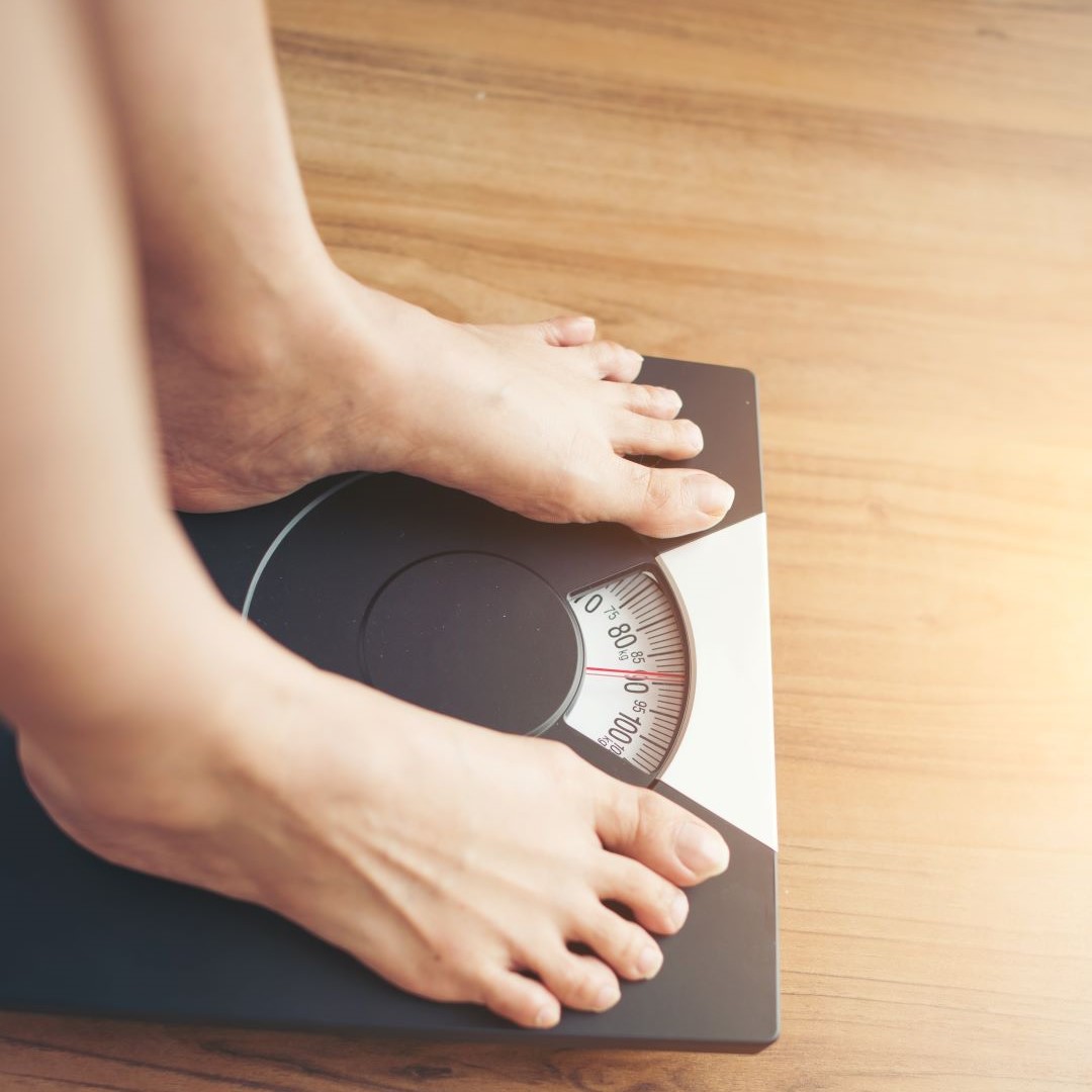 woman feet standing weight scale wooden background