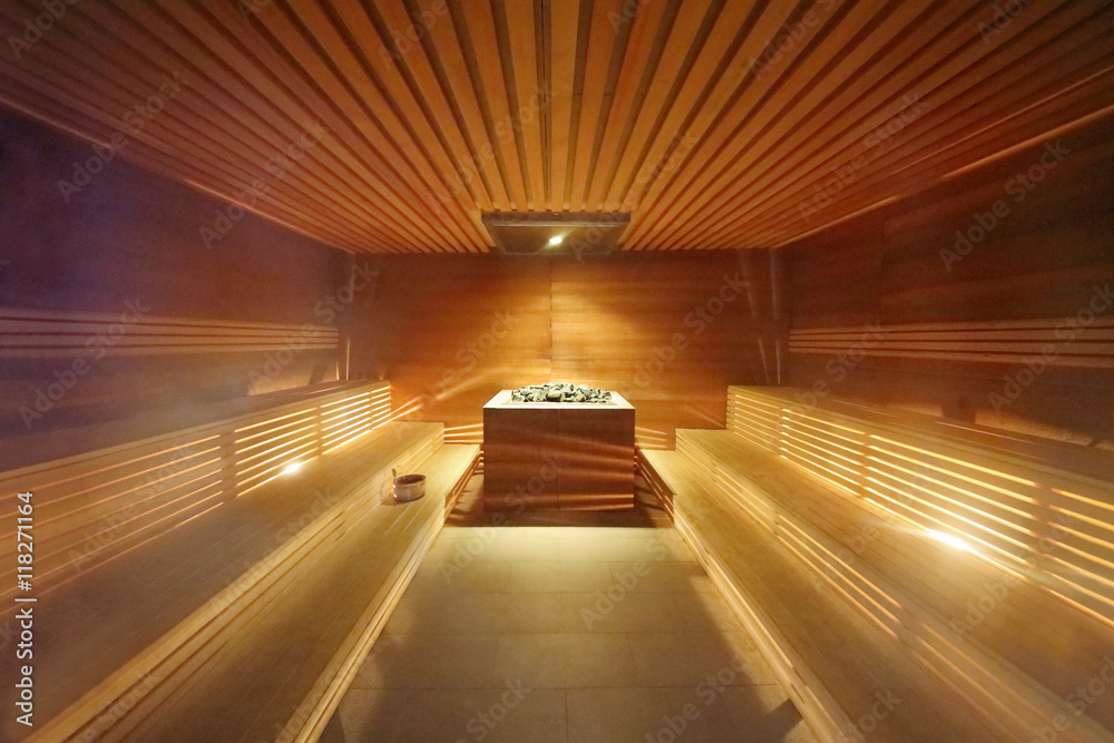 Interior inside the sauna room with wooden benches and hot stones